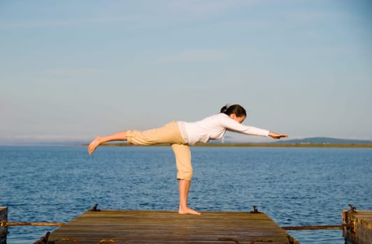 Yoga Woman on a dock by the ocean