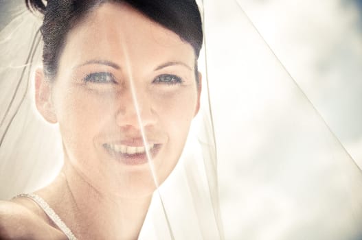 White Bride at her wedding posing with veil