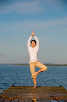 Yoga Woman on a dock by the ocean
