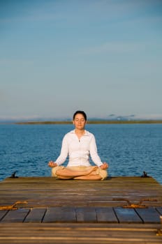 Yoga Woman on a dock by the ocean