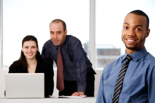 three business associates with a grey laptop