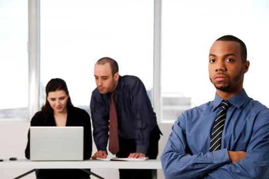 three business associates with a grey laptop