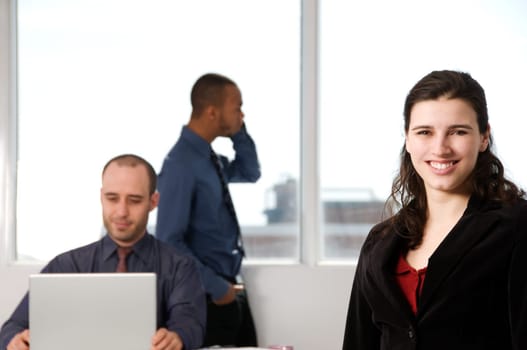 three business associates with a grey laptop