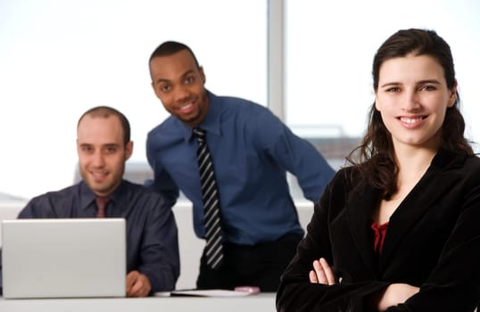 three business associates with a grey laptop