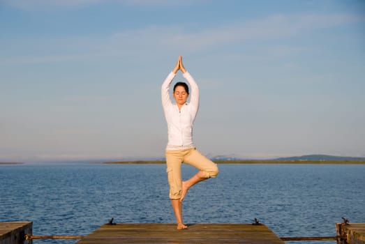 Yoga Woman on a dock by the ocean