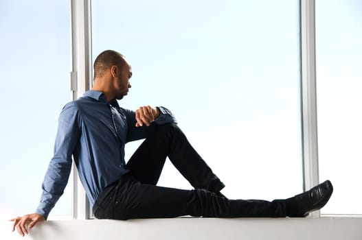 business man sitting on a window frame