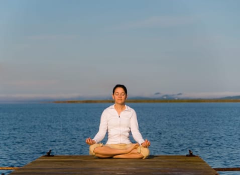 Yoga Woman on a dock by the ocean