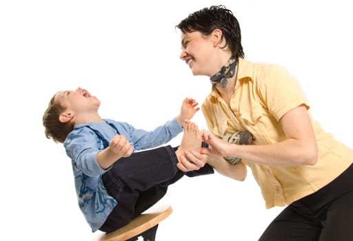 mom tickling son's feet and laughing hard