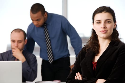 three business associates with a grey laptop