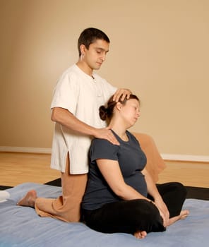 therapist stretching client's neck in massage thai