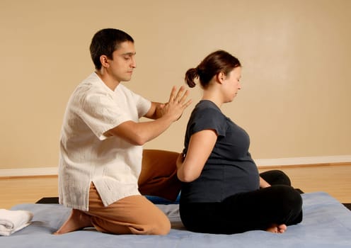 therapist giving thai massage to female client