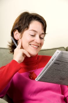 cute woman reading the newspaper on couch