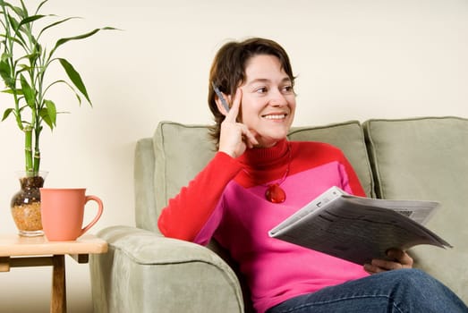 cute woman on couch looking at newspaper