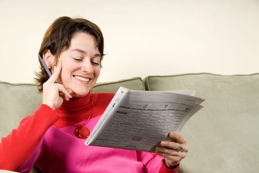 cute woamn reading the classifieds on couch