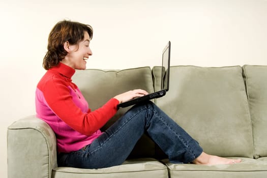 woman on sofa with black laptop on knees