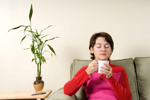 calm woman drinking from a white cup