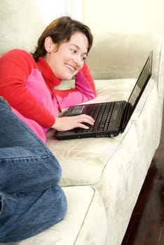 woman relainx on the couch with laptop