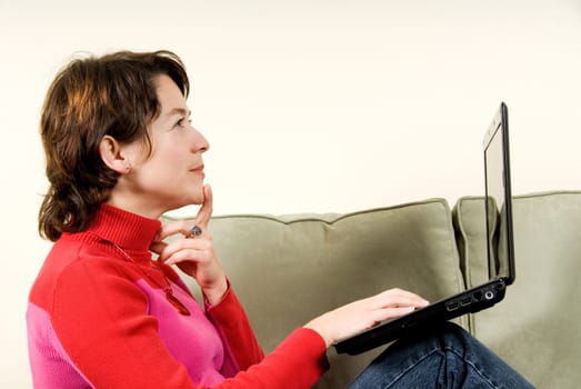 woman with balk laptop thinking on couch