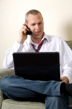 businessman chattin gon the phone with a laptop