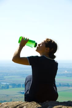 drinking woman on top of a mountain