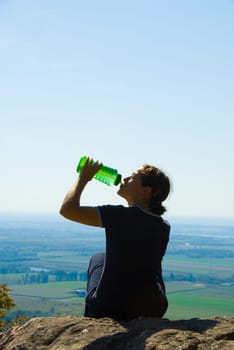 drinking woman on top of a mountain