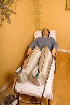 man in a spa with pressotherapy legs on