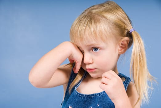 little cute blond girl on a blue wall