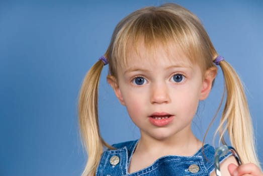 little cute blond girl on a blue wall