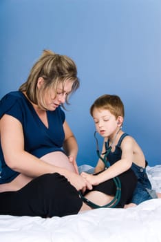 cute blond boy listening to the unborn child