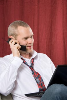 businessman talking on cell phone with laptop