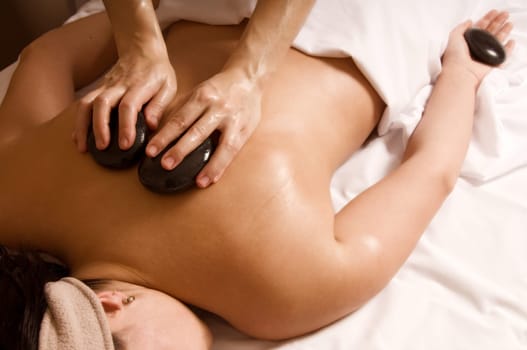 Therapist giving a hot stone massage to client