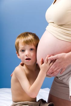 cute blond boy listening to the unborn child