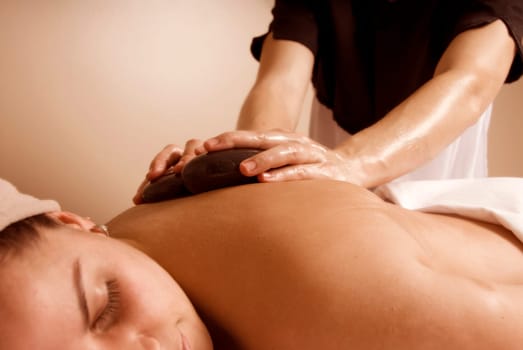 woman in a day spa getting a stone massage