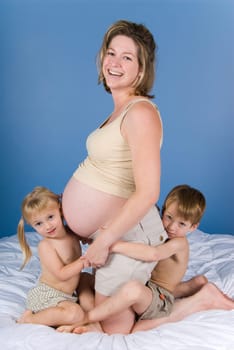 two cute kids with their pregnant mother