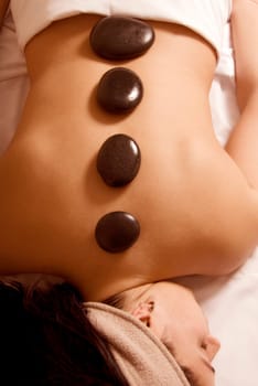 cute girl getting a stone massage in a spa
