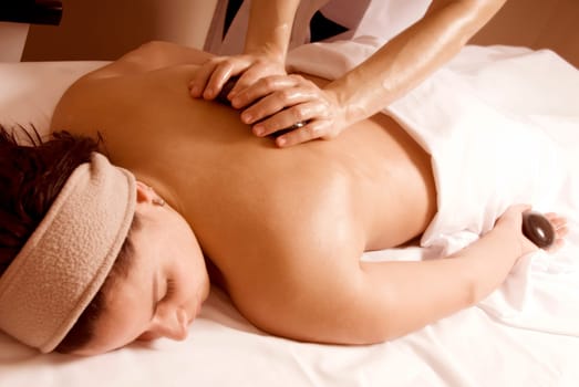 woman in a day spa with stone massage