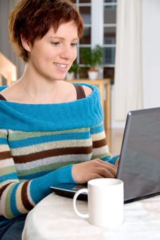 woman sitting at a table with her laptop