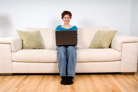 woman on her laptop sitting on the sofa