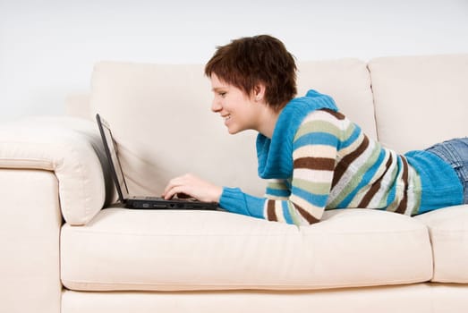 cute woman on her couch with her laptop