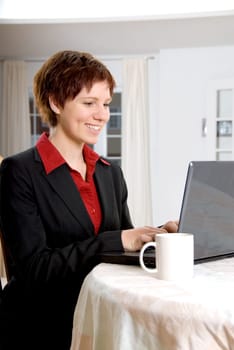 woman in a black suit working on her laptop
