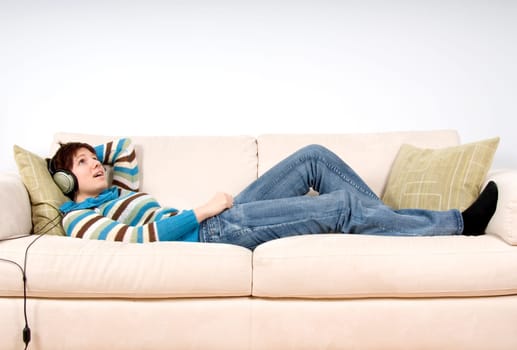 cute woman lying on the sofa with headphones