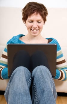 cute girl with her laptop back against the couch