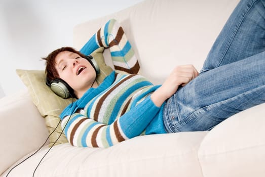 cute girl lying on the sofa listening to music