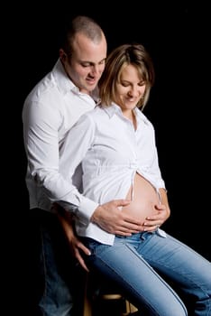 pregnant woman and her boyfriend on black background