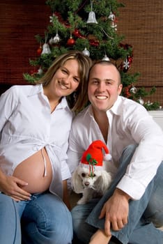 happy merry couple in front of the xmas tree
