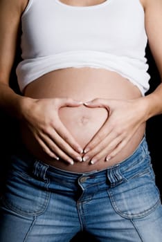pregnant woman doing a heart shape with hands