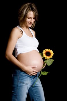pregnant woman on black with a sunflower