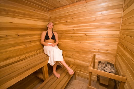 cute woman relaxing in the wood sauna