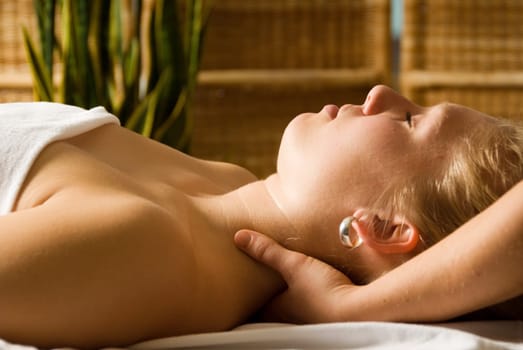 woman in a day spa getting a neck massage by therapist