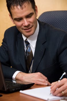 Businessman in a board room with his grey laptop